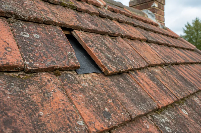Roof repair in Banbury: illustration of a clay tile slipped out of line with the felt showing underneath